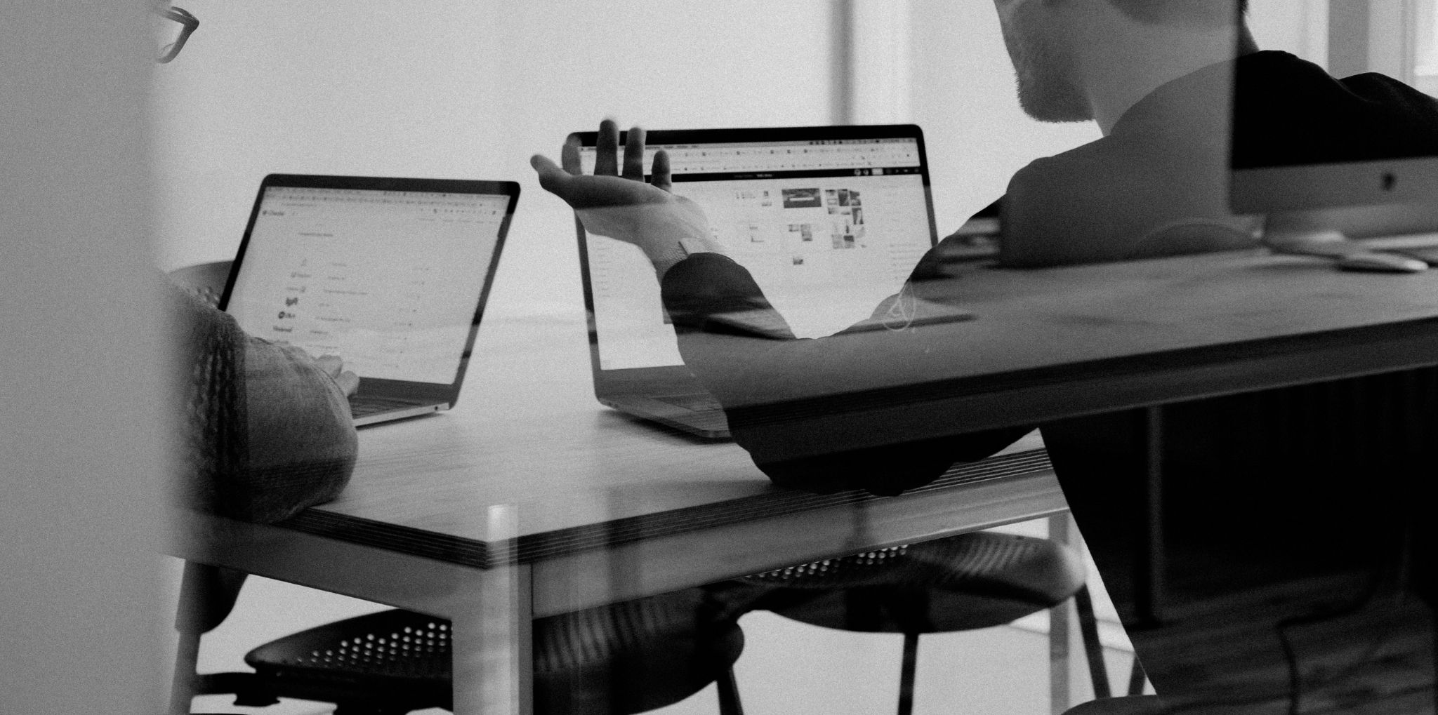 Two people working at laptop screens 